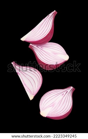 Flying red onions, isolated on black background
