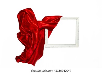 Flying Red Satin Cloth Unveiling A White Vintage Frame. Levitating Frame, Mockup For Presentation Or Display.