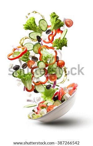 flying salad isolated on white background. Greek salad: red tomatoes, pepper, cheese, lettuce, cucumber, olives and olive oil