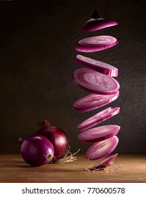 Flying Sliced Red Onion Rings On Dark Background