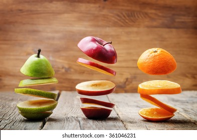 flying slices of fruit: apple, pear, orange on a dark wood background. toning. selective Focus - Powered by Shutterstock