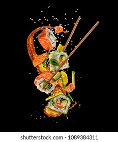 Flying sushi pieces isolated on black background. Concept of food levitation, high resolution image