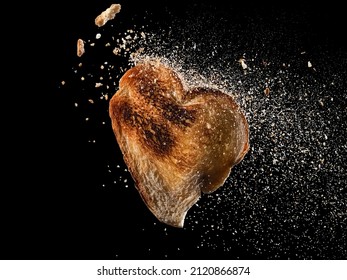 Flying Toasted Bread Heart Shape Slice With Crumbs Explosion On Black Background 