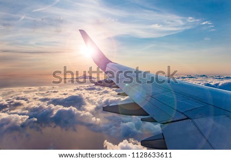 flying and traveling, view from airplane window on the wing on sunset time