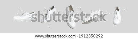 Flying white leather womens sneakers isolated on gray background, different kind. Fashionable stylish sports casual shoes. Creative minimalistic layout with footwear. Advertising for shoe store, blog