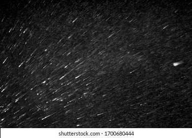 Flying white spatter spray or blizzard snow storm on black background, texture, overlay - Shutterstock ID 1700680444