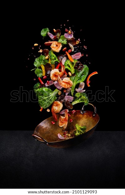 Flying wok ingredients -\
shrimp, vegetables, pak choi leaves, onions and peanuts. Asian food\
delivery. Chinese recipes. Wok preparation ingredients. Vertical\
image.