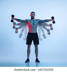 Flying. Young Caucasian Bodybuilder Training Over Blue Background In Neon And Strobe Light. Muscular Male Model With The Weight. Concept Of Sport, Bodybuilding, Healthy Lifestyle, Motion And Action.