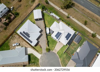 Flyover Suburban Homes Showing Roof Tops, Yards, Road And Street