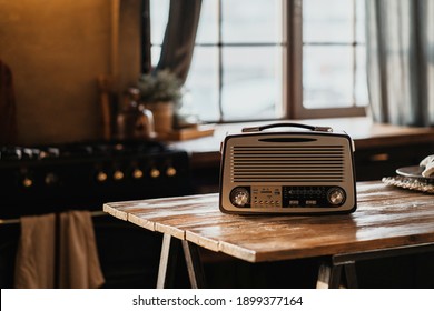 The FM channel is playing music, a stylish retro radio player stands on a wooden table. stylish kitchen in the village, daylight from the window. copy space - Shutterstock ID 1899377164