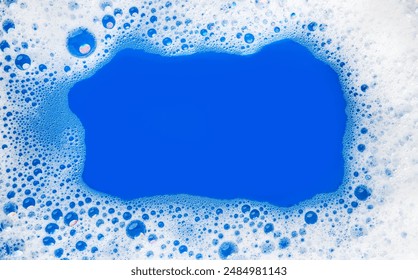 Foam background. Liquid soap bubbles, Frame made of Froth bubbles, on blue backdrop. Soap foam structure. Soap sud macro, close-up. Clean, cleaning, washing, laundry. Top view, copy space for text  - Powered by Shutterstock