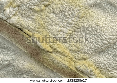 Foam covers ceiling for insulation. Internal construction work. Wooden beam, concrete walls. Repair
