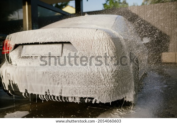 Foam flying\
from water gun, hand car wash\
station