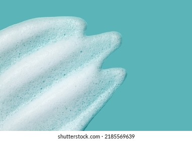 Foam Lather Texture Background. White Cleanser Gel, Shaving Foam, Shampoo Bubbles On Blue.