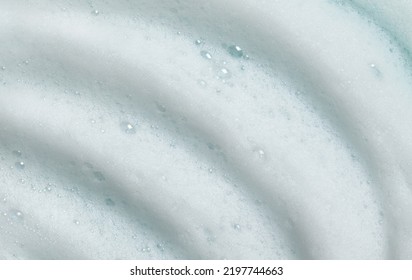 Foam Lather Texture Background. White Cleanser Gel, Shaving Foam, Shampoo Bubbles On Blue.