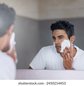 Foam, mirror and reflection of man in bathroom for hygiene, grooming and washing face at home, house and apartment. Male person, gen z guy and shaving cream on student with soap, hands and skin care - Powered by Shutterstock