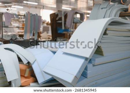 Foam padding sheets and other materials stacked and ready to be used in a furniture factory, showing the process of sofa production