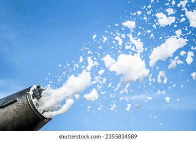 Foam party, foam cannon against the blue sky.Soap foam flies from a cannon against the sky.