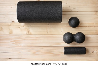 Foam roll, massage roll, balls on wooden background. MFR.