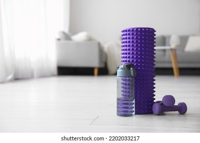 Foam Roller With Bottle Of Water And Dumbbells In Living Room