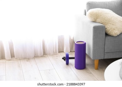 Foam Roller And Dumbbell Near Sofa In Living Room