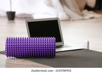 Foam Roller And Laptop On Mat In Bedroom, Closeup