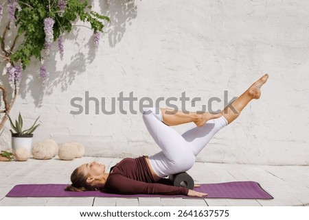 Foam roller pilates pose for core strength, balance, flexibility, and recovery. Outdoor wellness, stretching, and fitness routine for a healthy lifestyle.