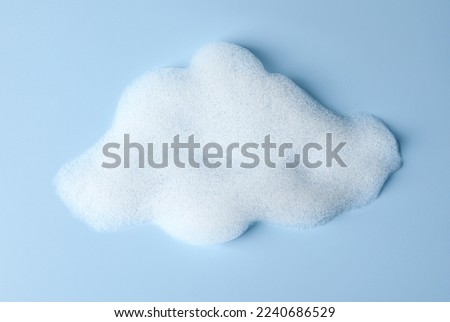 Foam sample in shape of cloud on light blue background, top view