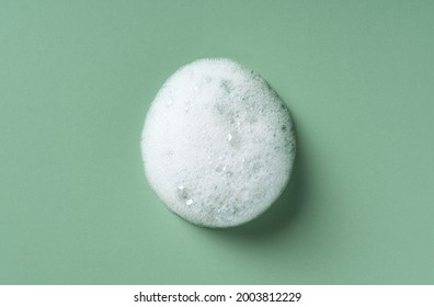 Foam Texture On Green Background. Soap, Shampoo, Mousse, Shower Gel Foam.