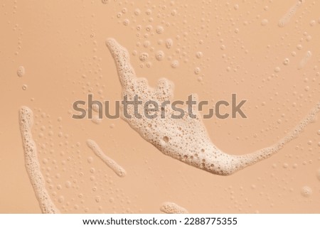 Foam texture on a pink background. A sample of facial foam. 