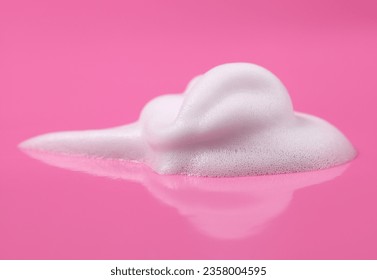 of foam texture, white bubbles from soap, shampoo or shower gel. and facial cleansing foam isolated on pink background