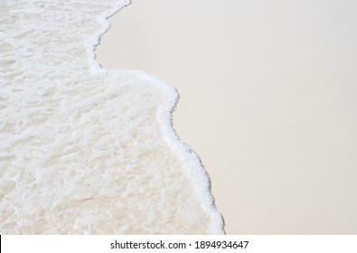 Foam wave and white sand on the beach. Sea wave on sand beach photo background. Coral beach sand with sea wave. White sand of oceanic coastline. Exotic island seaside banner with place for text. - Powered by Shutterstock