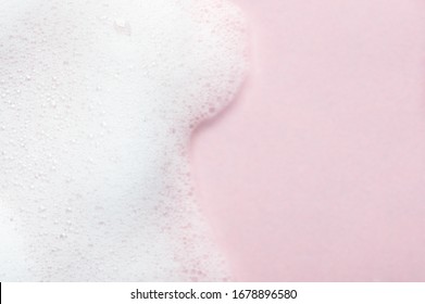 Foaming liquid on pink backdrop. Cosmetics foam background with copy space in right side. Cosmetic product sample of mousse, shampoo or soap. Skincare, cosmetology and beauty concept - Powered by Shutterstock