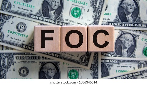 FOC - Free Of Charge Symbol. Concept Word 'FOC - Free Of Charge' On Cubes On A Beautiful Background From Dollar Bills. Business And FOC - Free Of Charge Concept.