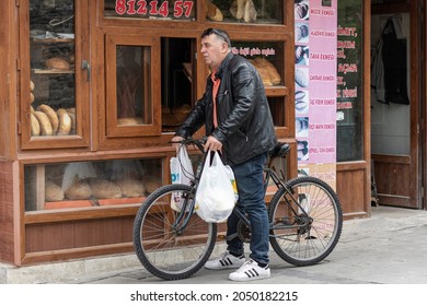 Foca, Izmir, Turkey - 05052019: A Man On A Bicycle Takes Bread From The Oven