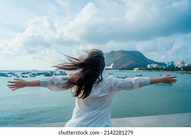 Focus Back View Happy Asian Girl Raises Her Hands Up In Front Of Beach At Vung Tau. Travel Concept. Concept Welcoming, Relaxing And Enjoying.