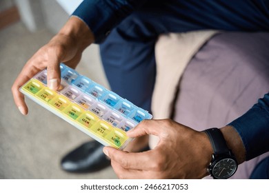 Focus of box with pills in hands of partial african american businessman on bed - Powered by Shutterstock