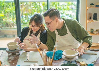 Focus couple potter working on potters wheel making ceramic pot from clay in pottery workshop. Couple in love working together in potter studio workshop. - Powered by Shutterstock