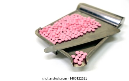 Focus Foreground At Pink Round Pills Placed On The Stainless Steel Counting Tray With Divide Spatula For The Separate And Count Its At Clinic, Hospital Or Pharmacy. White Table And Blurred Background