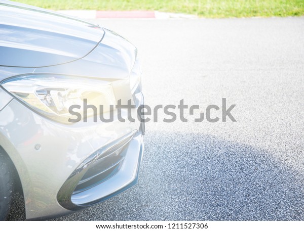 Focus front of Luxury car headlights\
High Voltage Light Bulb and Front bumper on\
racetrack.
