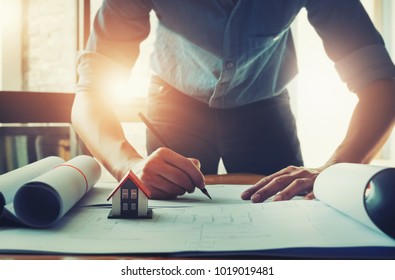 focus house model, Architect design concept. Young engineer drawing of house structure on blueprint to present Customer. Engineering concept.