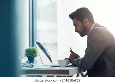 Focus and intention will get you far. Shot of a handsome young businessman using a laptop and cellphone at his desk in a modern office. - Powered by Shutterstock