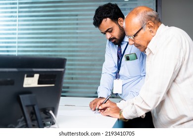 Focus On Banker, Employee Helping Or Guiding Old Man To Fill Receipt Or To Fill Banking Documents At Desk - Concept Of Client Agreement, Elderly Support And Banking Customer Service.
