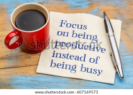 Focus on being productive instead of being busy - handwriting on a napkin with a cup of espresso coffee
