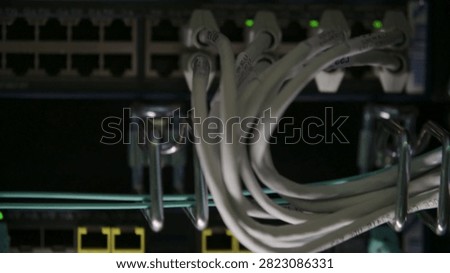 Focus on cables linking to network switches in a data center. Close-up reveals electronic details and sophisticated technology in an important infrastructure setting.