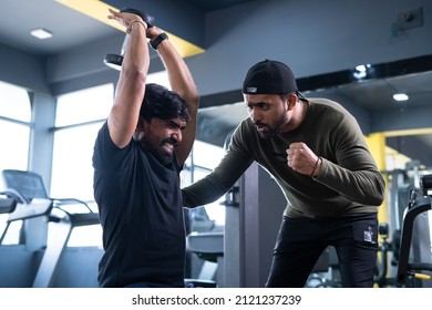 Focus On Client, Trainer Motivating Athlete To Push His Limits During Workout At Gym - Concept Of Intense Exercise, Bodybuilding, Determination And Personal Trainer