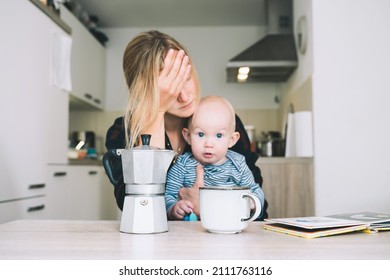 Focus On Coffee Maker And Cup, Background People Blurred. Modern Young Tired Mom And Little Child After Sleepless Night. Exhausted Woman With Baby Is Sitting With Coffee In Kitchen. 