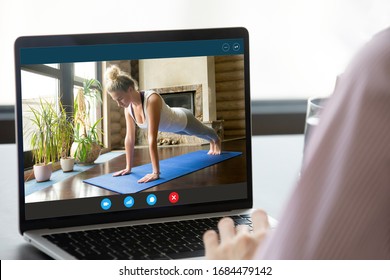 Focus On Computer Screen With Fit Young Woman Standing In Plank Position, Enjoying Practicing Yoga On Mat Alone At Home. Strong Female Fitness Trainer Giving Online Educational Pilates Workshop.