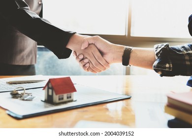 Focus on the congratulatory handshake. The real estate agent agrees to buy the home the customer at the agent's office. concept agreement.