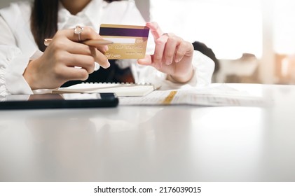 Focus On Credit Card In Hand Young Asian Woman Holding Credit Card To Paying Online For An Order Via Mobile App And Checking Order In Bank Statement, Close Up View